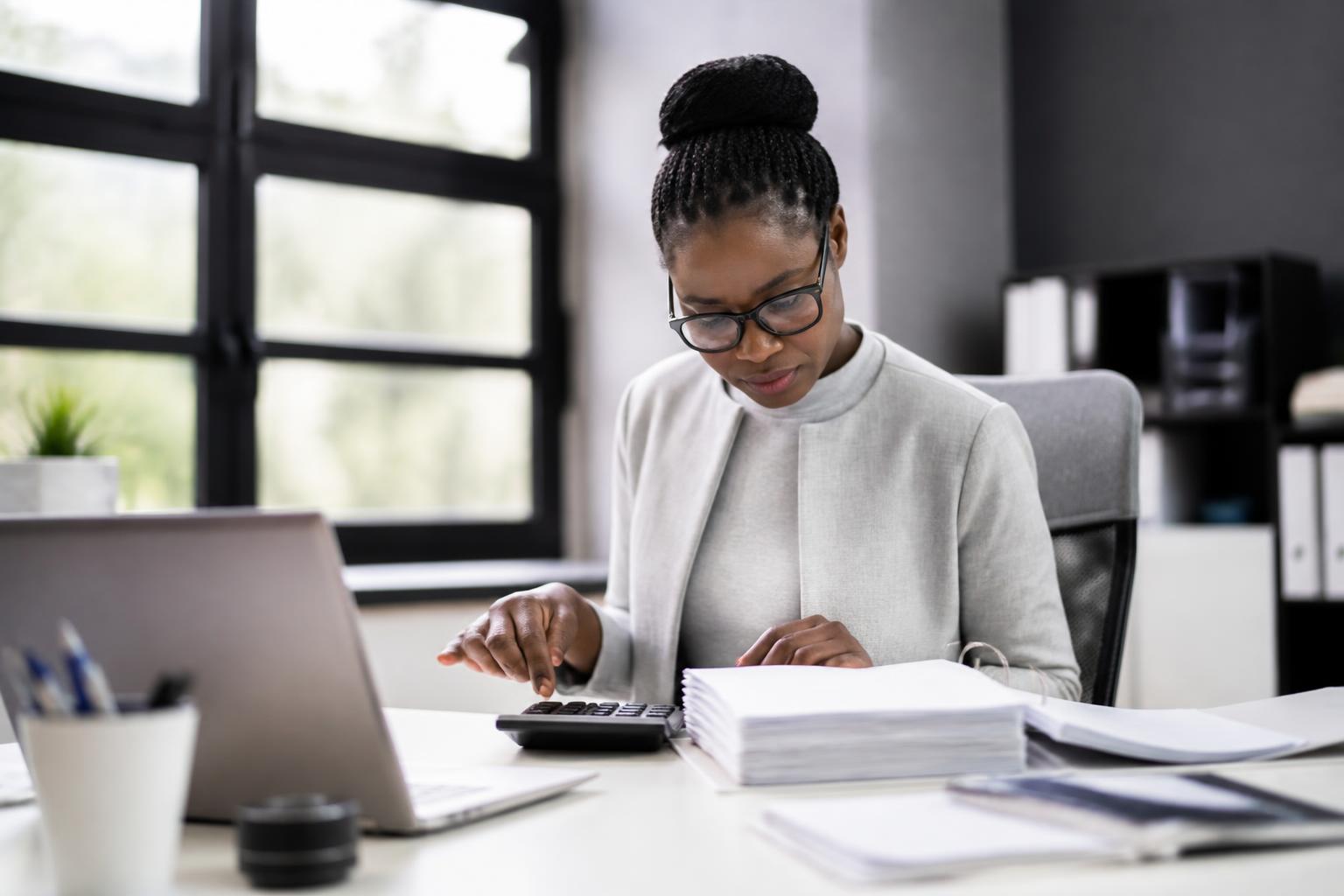 Comptable ivoirienne travaillant sur les états financiers d’une entreprise dans un bureau moderne